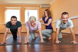 Gruppe macht Rehasport im Fitnesscenter mit Fitnesstrainerin